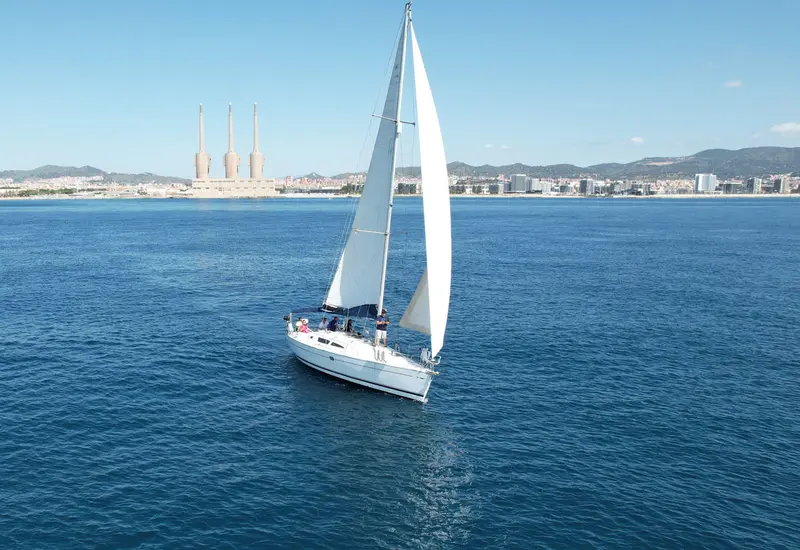 Aerial view of a sailing yacht anchored at a hidden cove with crystal-clear turquoise water in Mallorca