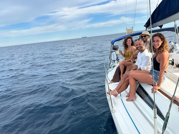 Private yacht sailing past dramatic pine-covered cliffs of Mallorca's west coast